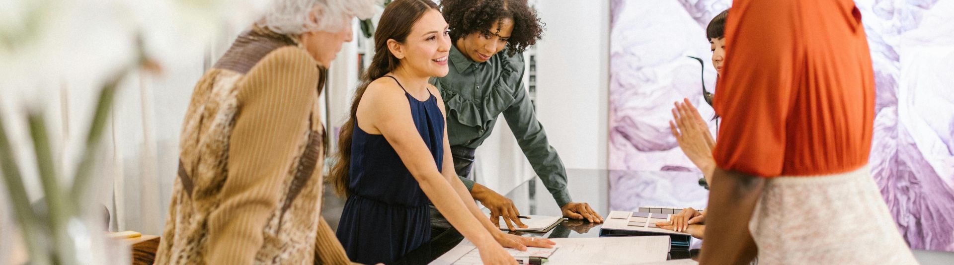 A diverse group of businesswomen discussing ideas together in a modern office setting.